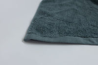 Close-up of a teal towel on a light gray background