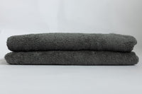 Two gray towels stacked on a white background