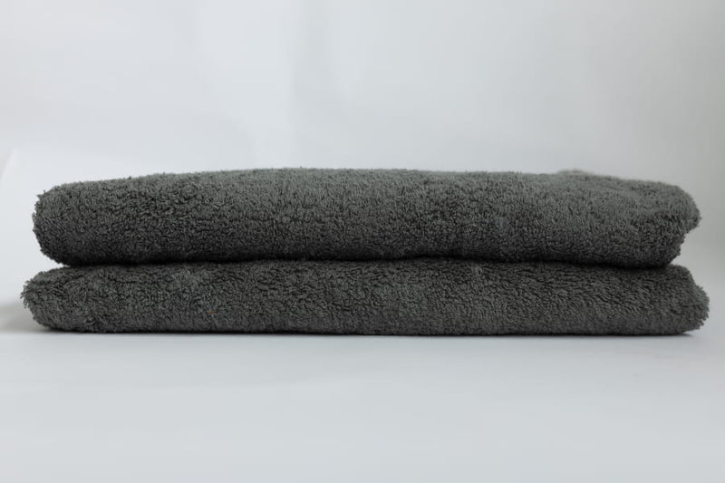 Two gray towels stacked on a white background